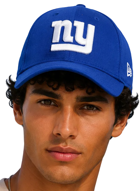 A close-up portrait of a man wearing a royal blue New York Giants baseball cap with a white embroidered 'ny' logo on the front and a white New Era flag on the side, set against a solid light blue background.
