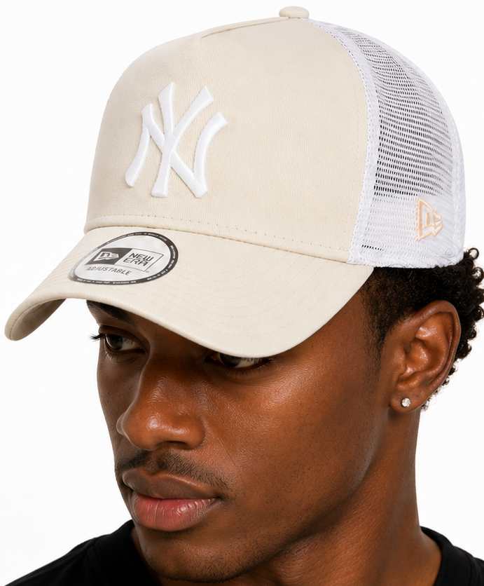 A man shown from the front and back wearing a New Era New York Yankees trucker hat. The hat features a cream-colored front panel with the white embroidered New York Yankees logo, white mesh back panels, and a white visor with a black New Era sticker.