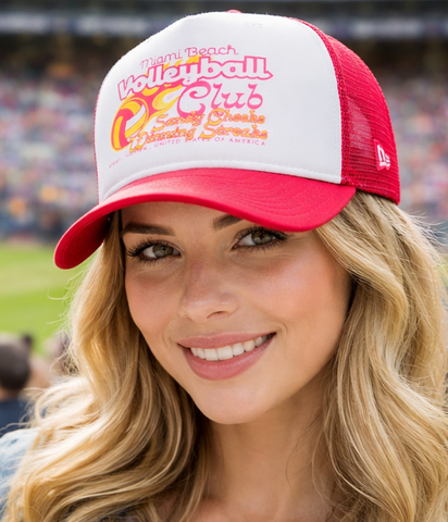 Woman wearing a red and white baseball cap with a stadium in the background