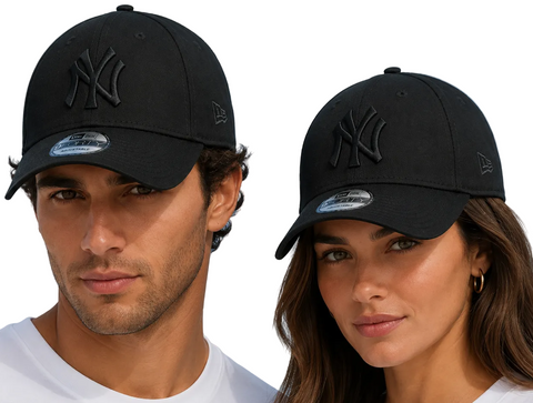 A man and a woman wearing black New Era baseball caps with a tonal black New York Yankees logo, set against a bright blue sky background.