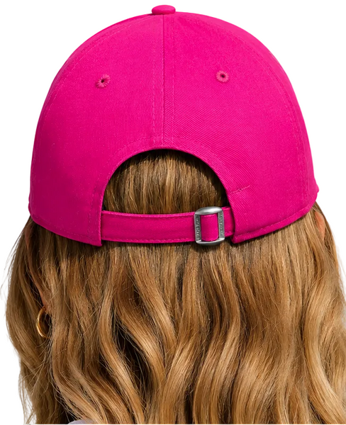 Two people shown from behind wearing bright pink baseball caps with adjustable straps and silver buckles, set against a solid light blue background.