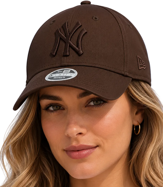 A woman wearing a dark brown New York Yankees baseball cap with a tonal embroidered logo and a curved visor, photographed against a clean white background.