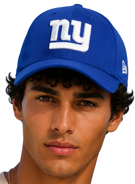A close-up portrait of a man wearing a royal blue New York Giants baseball cap with a white embroidered 'ny' logo on the front and a white New Era flag on the side, set against a solid light blue background.