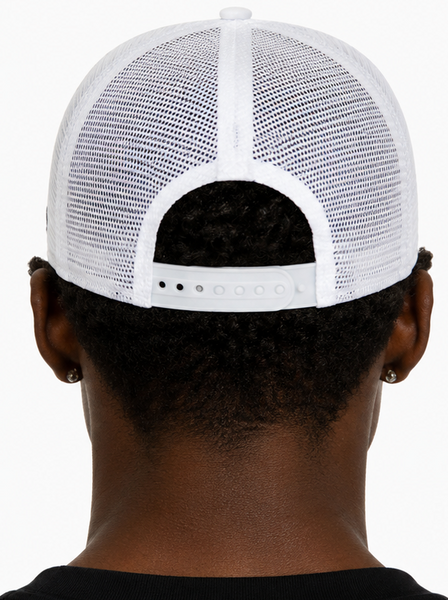 A man wearing a white New York Yankees trucker hat, shown in side profile and back view against a light gray background.